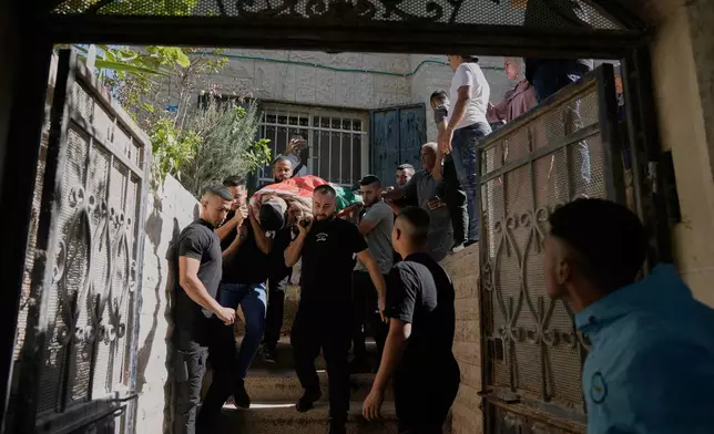 Mourners carry the body of the Palestinian Mohammed Salama, 25, who was killed in an Israeli military raid, during his funeral in the West Bank city of Jenin, Saturday, Oct. 11, 2025. (AP Photo/Majdi Mohammed)