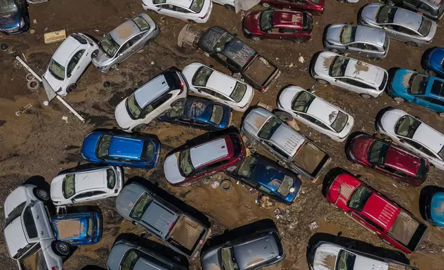 Damaged vehicles sit in mud after flooding in Poza Rica, Veracruz state, Mexico, Sunday, Oct. 12, 2025. (AP Photo/Felix Marquez)