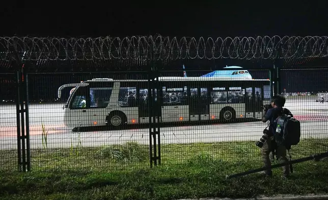 Korean Air staff and police officers ride a bus at Techo International Airport in Kandal province, Cambodia, Friday, Oct. 17, 2025. (AP Photo/Heng Sinith)