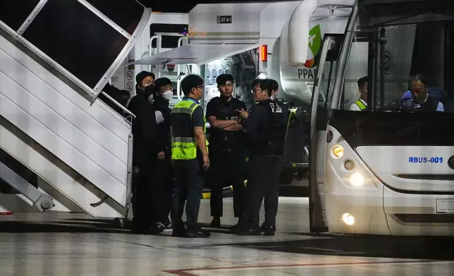 A Korean Air staff speaks with police officers at Techo International Airport in Kandal province, Cambodia, Friday, Oct. 17, 2025. (AP Photo/Heng Sinith)