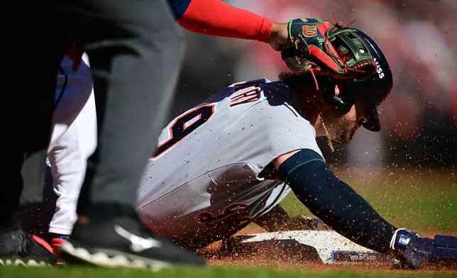 Detroit Tigers' Zach McKinstry slides and is out at third base by Cleveland Guardians third baseman José Ramírez, left, in the fourth inning of Game 2 of the American League Wild Card baseball playoff series in Cleveland, Wednesday, Oct. 1, 2025. (AP Photo/David Dermer)