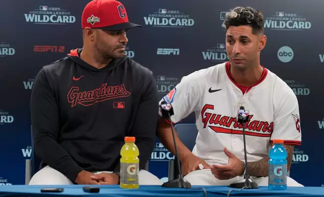 Cleveland Guardians shortstop Brayan Rocchio, right, and interpreter Agustin Rivero, left, participate in a news conference after Game 2 of the American League Wild Card baseball playoff series against the Detroit Tigers in Cleveland, Wednesday, Oct. 1, 2025. (AP Photo/Sue Ogrocki)