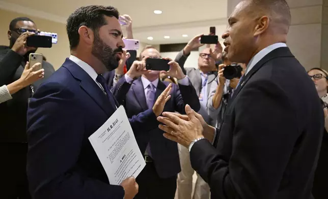 Rep. Michael Lawler, R-N.Y., left, confronts House Minority Leader Hakeem Jeffries, D-N.Y., in a heated discussion to endorse House bill H.R.5145 that would extend the American Rescue Plan Act of 2021 (ARPA) and the Inflation Reduction Act of 2022 at the U.S. Capitol on Wednesday, Oct. 8, 2025, in Washington. (AP Photo/John McDonnell)