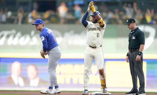 Milwaukee Brewers' Jackson Chourio (11) reacts to hitting a double as Chicago Cubs second baseman Nico Hoerner (2) looks on during the first inning in Game 1 of baseball's National League Division Series game Saturday, Oct. 4, 2025, in Milwaukee. (AP Photo/Kayla Wolf)
