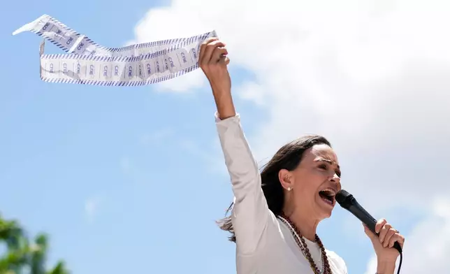 FILE - Opposition leader Maria Corina Machado holds up tally sheets during a protest against the reelection of President Nicolás Maduro one month after the disputed presidential vote which she says the opposition won by a landslide, in Caracas, Venezuela, Aug. 28, 2024. (AP Photo/Ariana Cubillos, File)