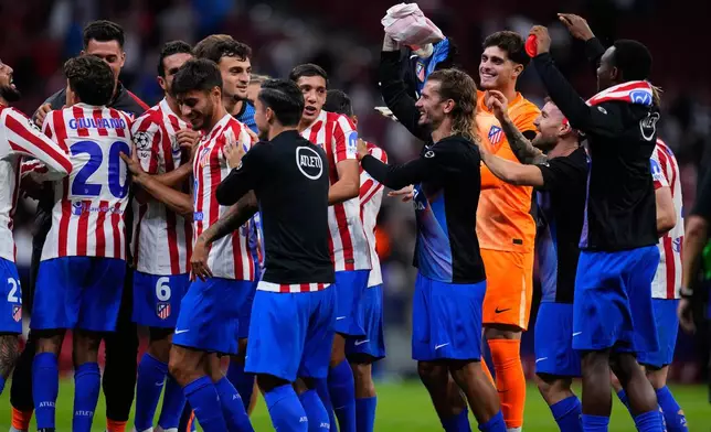 Atletico Madrid's Antoine Griezmann celebrates with team mates after the Champions League opening phase soccer match between Atletico Madrid and Eintracht Frankfurt at the Metropolitano stadium in Madrid, Spain, Tuesday, Sept. 30, 2025. (AP Photo/Manu Fernandez)