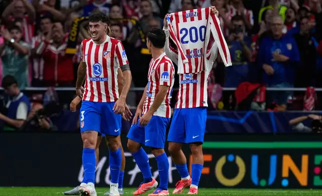 Atletico Madrid's Antoine Griezmann lifts a trikot after scoring his side's third goal during the Champions League opening phase soccer match between Atletico Madrid and Eintracht Frankfurt at the Metropolitano stadium in Madrid, Spain, Tuesday, Sept. 30, 2025. (AP Photo/Manu Fernandez)