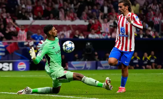 Atletico Madrid's Antoine Griezmann and Frankfurt's goalkeeper Kaua Santos challenge for the ball during the Champions League opening phase soccer match between Atletico Madrid and Eintracht Frankfurt at the Metropolitano stadium in Madrid, Spain, Tuesday, Sept. 30, 2025. (AP Photo/Manu Fernandez)