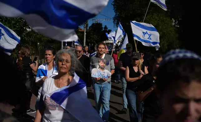 Mourners gather near the car carrying the coffin of slain hostage Guy Illouz during his funeral procession in Rishon Lezion, Israel, Wednesday, Oct. 15, 2025. Illouz remains were returned from Gaza to Israel as part of a ceasefire agreement between Israel and Hamas. (AP Photo/Emilio Morenatti)