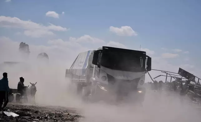 Trucks carrying aid from the World Food Programme (WFP) drive through in Khan Younis, southern Gaza Strip, Wednesday, Oct. 15, 2025. (AP Photo/Jehad Alshrafi)