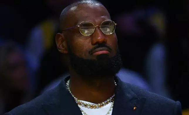 Los Angeles Lakers forward Lebron James sits on the bench during the first half of an NBA basketball game against the Golden State Warriors, Tuesday, Oct. 21, 2025, in Los Angeles. (AP Photo/Ethan Swope)