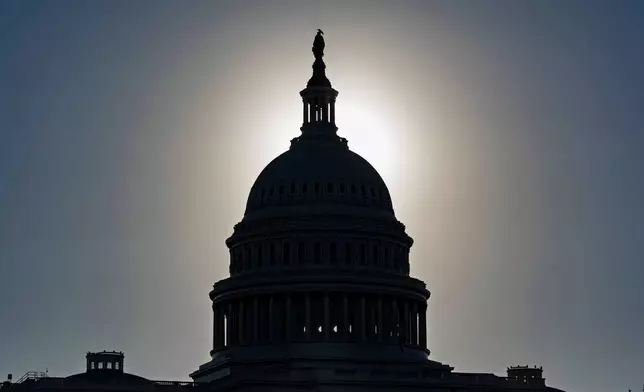 The U.S. Capitol is silhouetted by the stark glare of the morning sun as a government shutdown begins its tenth day, in Washington, Friday, Oct. 10, 2025. (AP Photo/J. Scott Applewhite)