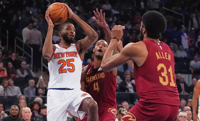 New York Knicks' Mikal Bridges (25) drives past Cleveland Cavaliers' Evan Mobley (4) and Jarrett Allen (31) during the second half of an NBA basketball game Wednesday, Oct. 22, 2025, at Madison Square Garden in New York. (AP Photo/Frank Franklin II)
