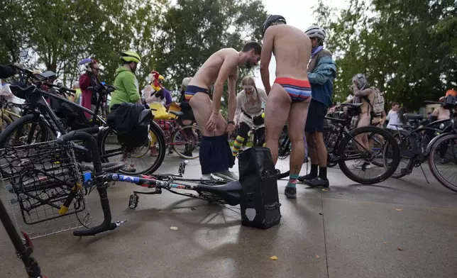 Participants prepare for the Naked Bike Ride protest on Sunday, Oct. 12, 2025, in Portland, Ore. (AP Photo/Jenny Kane)