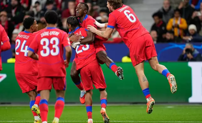 PSG's Willian Pacho celebrates with his teammates after scoring his side's first goal during a Champions League opening phase soccer match between Bayer Leverkusen and Paris Saint-Germain in Leverkusen, Germany, Tuesday, Oct. 21, 2025. (AP Photo/Martin Meissner)