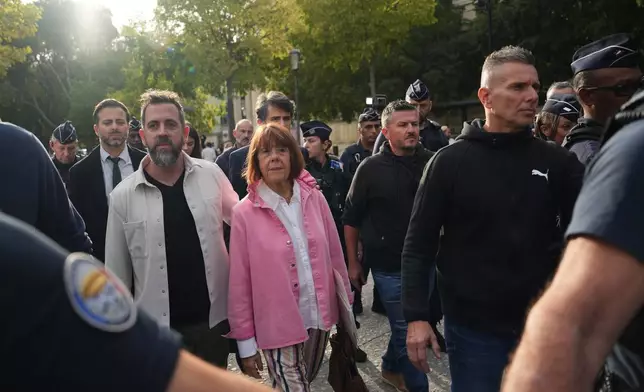 Gisele Pelicot and her son Florian Pelicot, left, leave the courthouse during the appeals trial in the case of a man challenging his conviction, less than a year after the landmark verdict in a drugging and rape trial that shook France Thursday, Oct. 9, 2025 in Nimes, southern France. (AP Photo/Lewis Joly)
