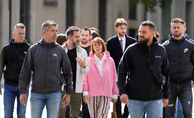 Gisele Pelicot and her son Florian Pelicot, third left, return to the courthouse during the appeals trial in the case of a man challenging his conviction, less than a year after the landmark verdict in a drugging and rape trial that shook France Thursday, Oct. 9, 2025 in Nimes, southern France. (AP Photo/Lewis Joly)