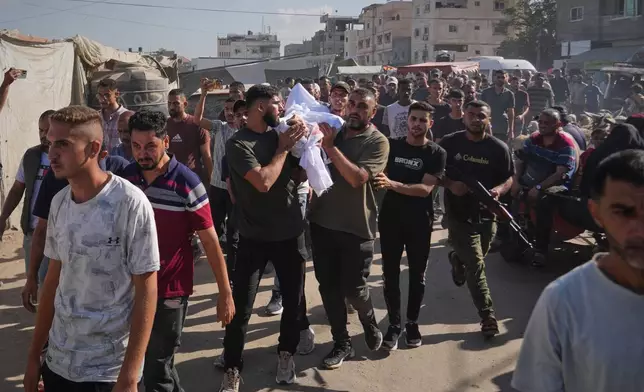 Palestinians carry the body of a man killed in an Israeli strike on Deir al-Balah, Gaza Strip, Wednesday, Oct. 1, 2025. (AP Photo/Abdel Kareem Hana)