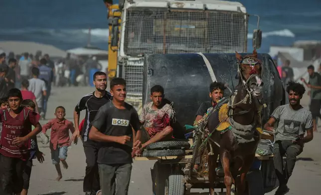 A Palestinian man injured by Israeli artillery fire targeting a group of civilians fleeing from northern Gaza to the south is evacuated on a horse-drawn cart, in central Gaza, Wednesday, Oct. 1, 2025. (AP Photo/Jehad Alshrafi)