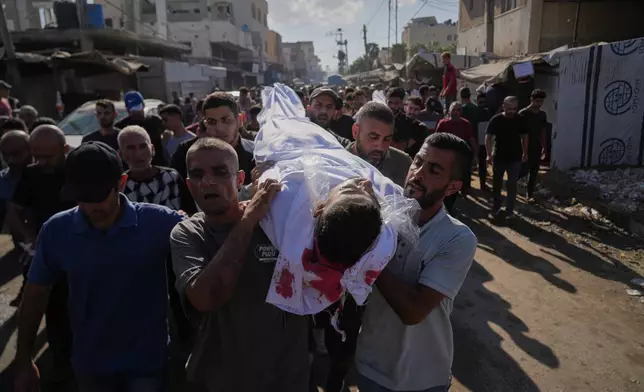 Palestinians carry the body of a man killed in an Israeli strike on Deir al-Balah, Gaza Strip, Wednesday, Oct. 1, 2025. (AP Photo/Abdel Kareem Hana)