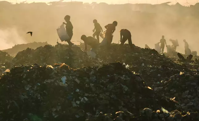 Displaced Palestinian children search for firewood and plastic in a landfill beside the makeshift tent camp where they are taking shelter, in Khan Younis, southern Gaza Strip, Tuesday, Sept. 30, 2025. (AP Photo/Jehad Alshrafi)