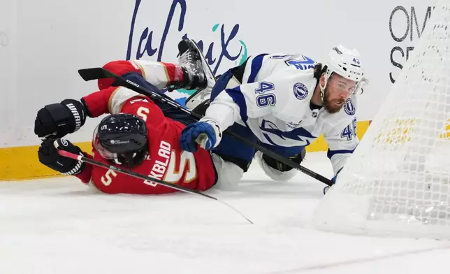 Florida Panthers defenseman Aaron Ekblad (5) and Tampa Bay Lightning right wing Scott Sabourin (46) fall to the ice during the first period of an NHL hockey preseason game, Saturday, Oct. 4, 2025, in Sunrise, Fla. (AP Photo/Lynne Sladky)
