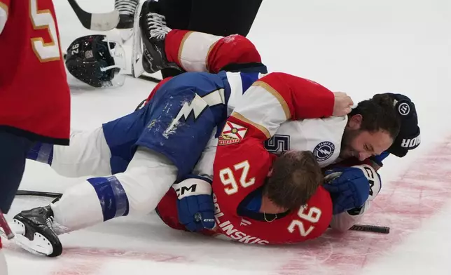 Florida Panthers defenseman Uvis Balinskis (26) and Tampa Bay Lightning Dylan Duke, right, scuffle during the third period of an NHL hockey preseason game, Saturday, Oct. 4, 2025, in Sunrise, Fla. (AP Photo/Lynne Sladky)