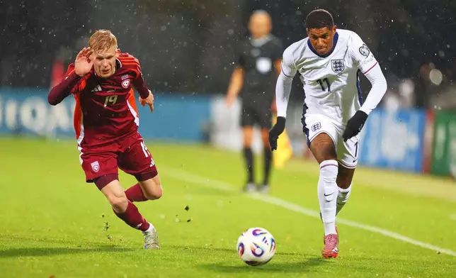 England's Marcus Rashford, right, and Latvia's Maksims Tonisevs in action during the 2026 World Cup group K qualifying soccer match between Latvia and England in Riga, Latvia, Tuesday, Oct. 14, 2025. (AP Photo/Roman Koksarov)