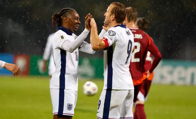 England's Eberechi Eze, left, celebrates with Harry Kane after scoring his side's fifth goal during the 2026 World Cup group K qualifying soccer match between Latvia and England in Riga, Latvia, Tuesday, Oct. 14, 2025. (AP Photo/Mindaugas Kulbis)