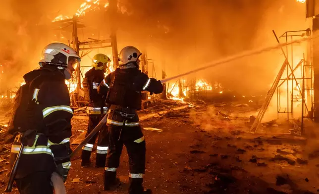 Firefighters tackle the blaze after a Russian air attack that hit at Barabashovo market in Kharkiv, Ukraine, Wednesday, Oct. 1, 2025. (AP Photo/Andrii Marienko)
