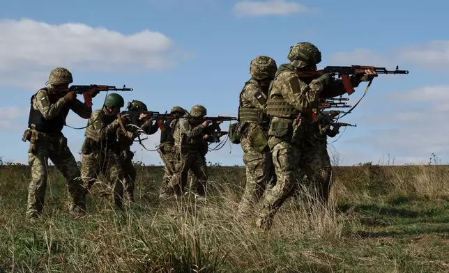 In this photo provided by Ukraine's 65th Mechanized Brigade press service, recruits run drills at a training ground in the Zaporizhzhia region, Ukraine, Friday, Sept. 26, 2025. (Andriy Andriyenko/Ukraine's 65th Mechanized Brigade via AP)