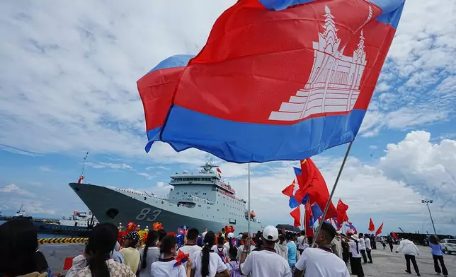 Chinese businessmen and local students gather as Chinese warship Qijiguang arrives at a commercial port in Sihanoukville, southern Cambodia, Friday, Oct. 10, 2025. (AP Photo/Heng Sinith)