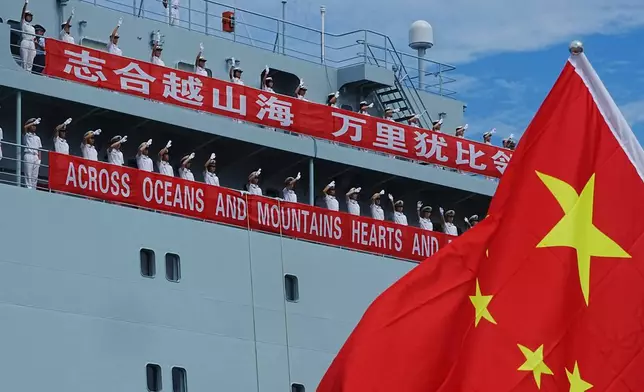 Chinese naval officials on their warship Qijiguang wave on the arrival at a commercial port in Sihanoukville, southern Cambodia, Friday, Oct. 10, 2025. (AP Photo/Heng Sinith)