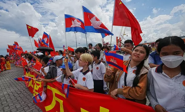 Local students gather as Chinese warship Qijiguang arrives at a commercial port in Sihanoukville, southern Cambodia, Friday, Oct. 10, 2025. (AP Photo/Heng Sinith)