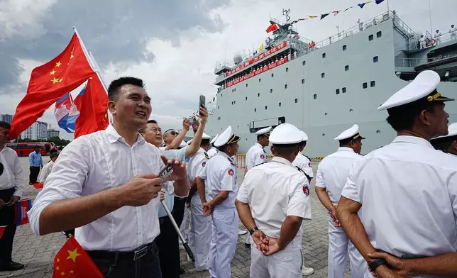 Cambodian naval officials, right, stand as Chinese warship Qijiguang arrives at a commercial port in Sihanoukville, southern Cambodia, Friday, Oct. 10, 2025. (AP Photo/Heng Sinith)