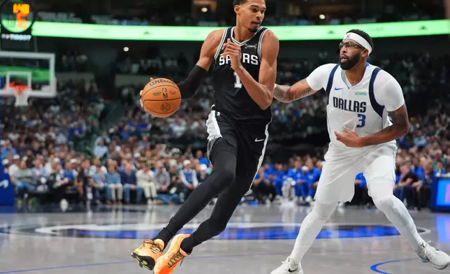 San Antonio Spurs forward Victor Wembanyama (1) drives against Dallas Mavericks forward Anthony Davis (3) during the first half of an NBA basketball game in Dallas, Wednesday, Oct. 22, 2025. (AP Photo/LM Otero)