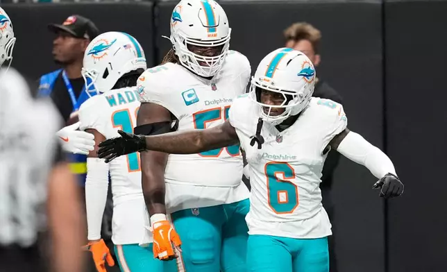Miami Dolphins wide receiver Malik Washington (6) is congratulated after scoring a touchdown during the first half of an NFL football game against the Atlanta Falcons, Sunday, Oct. 26, 2025, in Atlanta. (AP Photo/Mike Stewart)