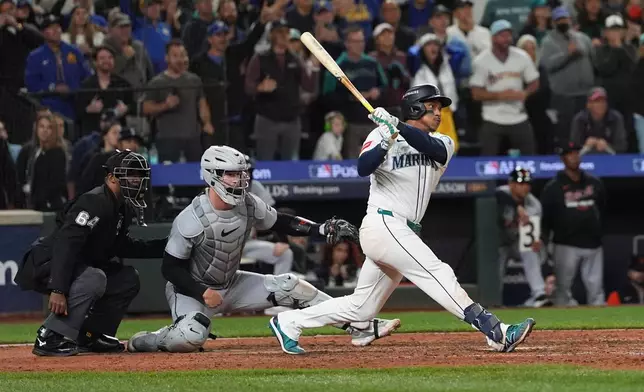 Seattle Mariners second baseman Jorge Polanco (7) hits an RBI-single for shortstop J.P. Crawford to score the game-winning run during the 15th inning in Game 5 of baseball's American League Division Series against the Detroit Tigers, Friday, Oct. 10, 2025, in Seattle. (AP Photo/Lindsey Wasson)