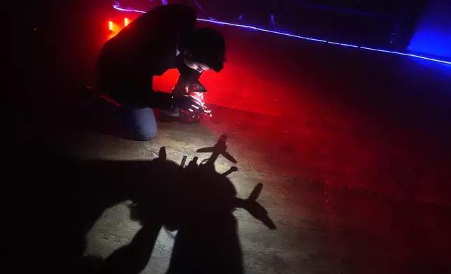 Colin Balfour, a sophomore studying robotics engineering, checks the rotors on a small drone at a laboratory at the Worcester Polytechnic Institute, Monday, Oct. 20, 2025, in Worcester, Mass. (AP Photo/Charles Krupa)