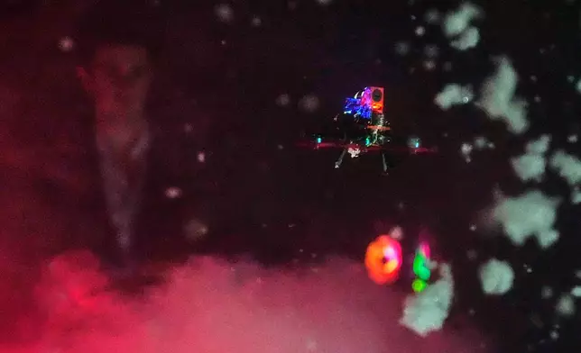 A tiny drone flies through a simulated snowstorm at night at a laboratory at Worcester Polytechnic Institute, Monday, Oct. 20, 2025, in Worcester, Mass. (AP Photo/Charles Krupa)