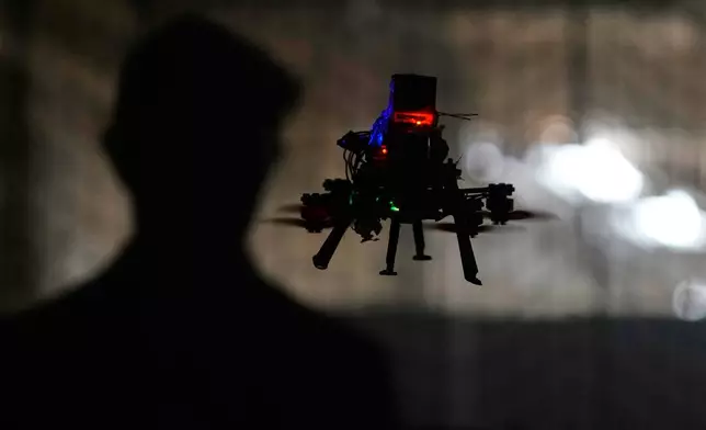 Colin Balfour, a sophomore studying robotics engineering, flies a small drone at a simulated night flight at a laboratory at the Worcester Polytechnic Institute, Monday, Oct. 20, 2025, in Worcester, Mass. (AP Photo/Charles Krupa)