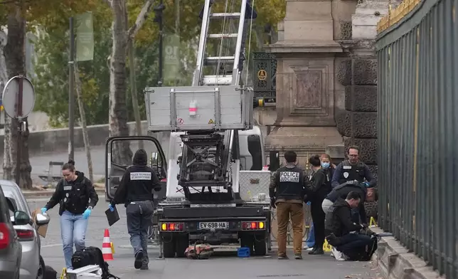 Police officers look for clues by a basket lift used by thieves Sunday, Oct. 19, 2025 at the Louvre museum in Paris. (AP Photo/Thibault Camus)