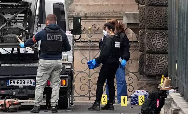 Police officers look for clues by a basket lift used by thieves Sunday, Oct. 19, 2025 at the Louvre museum in Paris. (AP Photo/Thibault Camus)