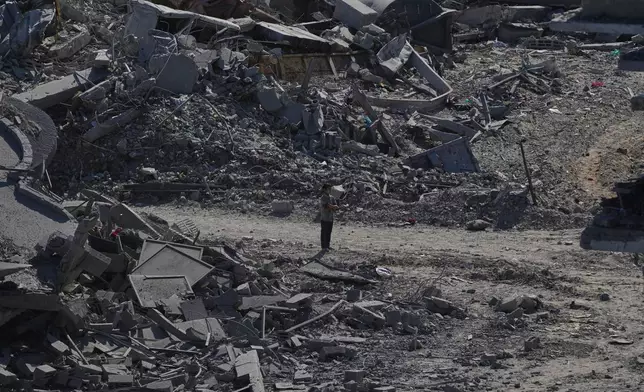 A Palestinian boy stands amid destroyed buildings in Gaza City, Saturday, Oct. 11, 2025, after Israel and Hamas agreed to a pause in their war and the release of the remaining hostages. (AP Photo/Abdel Kareem Hana)