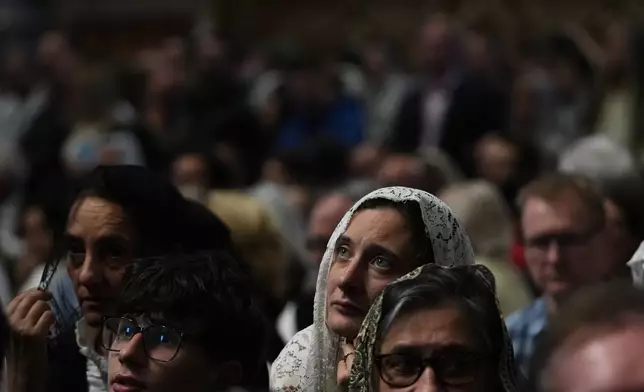 A woman attends a mass celebrated by Cardinal Raymond Leo Burke in St. Peter's Basilica, at the Vatican, Saturday, Oct. 25, 2025. (AP Photo/Alessandra Tarantino)