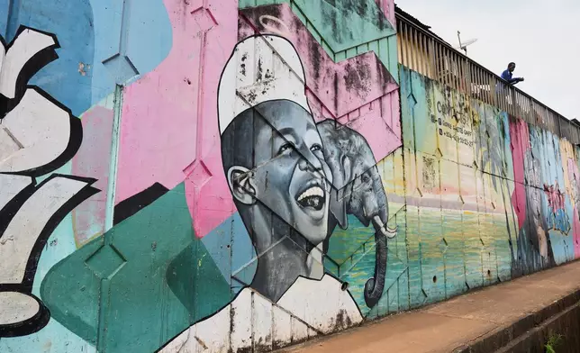 A mural depicting a smiling man with an elephant painted by Omar Diaw on a street wall in Conakry, Guinea, Saturday, Sep. 20, 2025. (AP Photo/Misper Apawu)