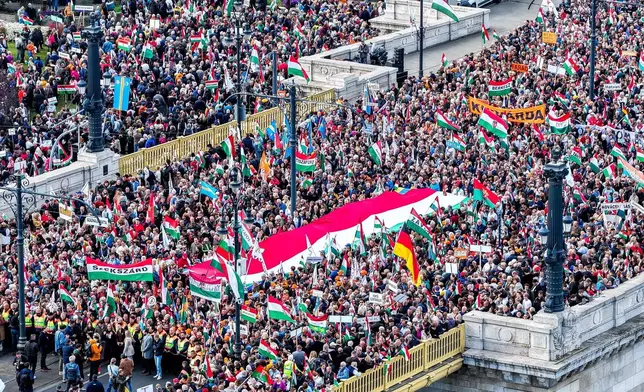 In this photo taken by a drone, participants of the Peace March organized by the pro-government Civil Unity Forum (COF) and its foundation Civil Unity Public Benefit Foundation (COKA) gather at the Buda side of Margaret Bridge in Budapest, Hungary, Thursday, Oct. 23, 2025, on the 69th anniversary of the Hungarian revolution and war of independence against communist rule and the Soviet Union in 1956. (Zsolt Czegledi/MTI via AP)