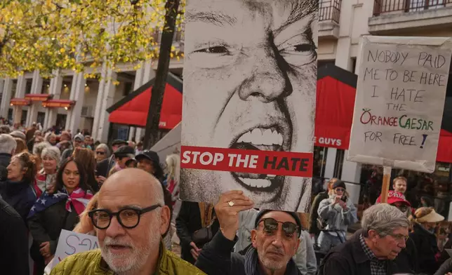 People attend a protest against U.S. President Donald Trump, in Paris, Saturday, Oct. 18, 2025. (AP Photo/Thibault Camus)