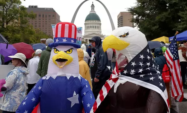 Demonstrators wearing inflatable bald eagle costumes gather in Kiener Plaza during the "No Kings" protest in St. Louis, with the Gateway Arch in the background, on Saturday, Oct. 18, 2025. (David Carson/St. Louis Post-Dispatch via AP)