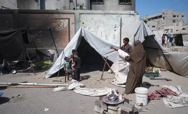 A family sets up a tent near a UN school used as a shelter for displaced Palestinians in Khan Younis, Tuesday, Sept 30, 2025. (AP Photo/Jehad Alshrafi)